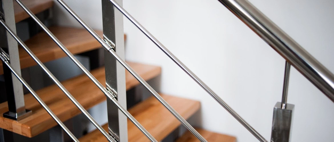 srebrne barierki przy drewnianych schodach